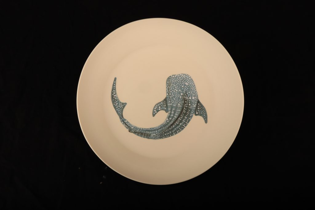 Whale shark painted on a circular ceramic plate.